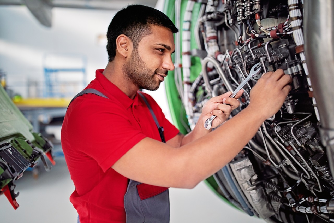 male mechanic working on engine